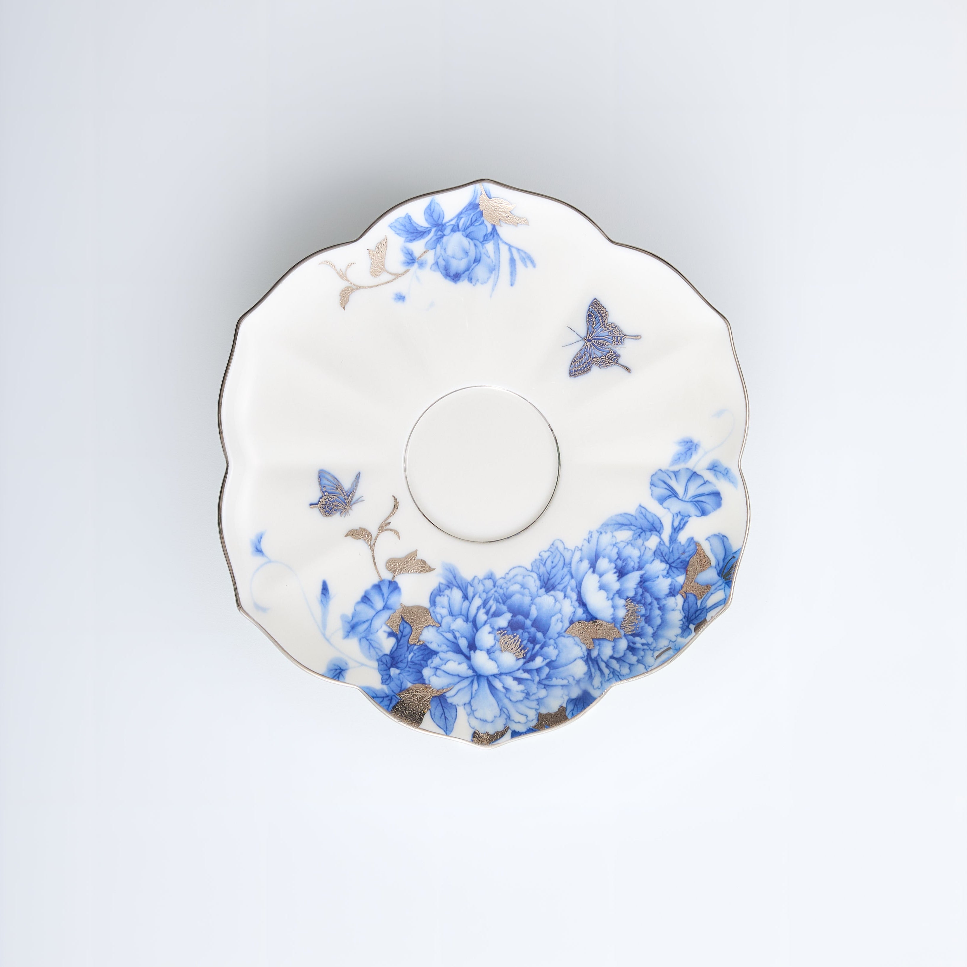 Floral-patterned ceramic saucer on a light gray background