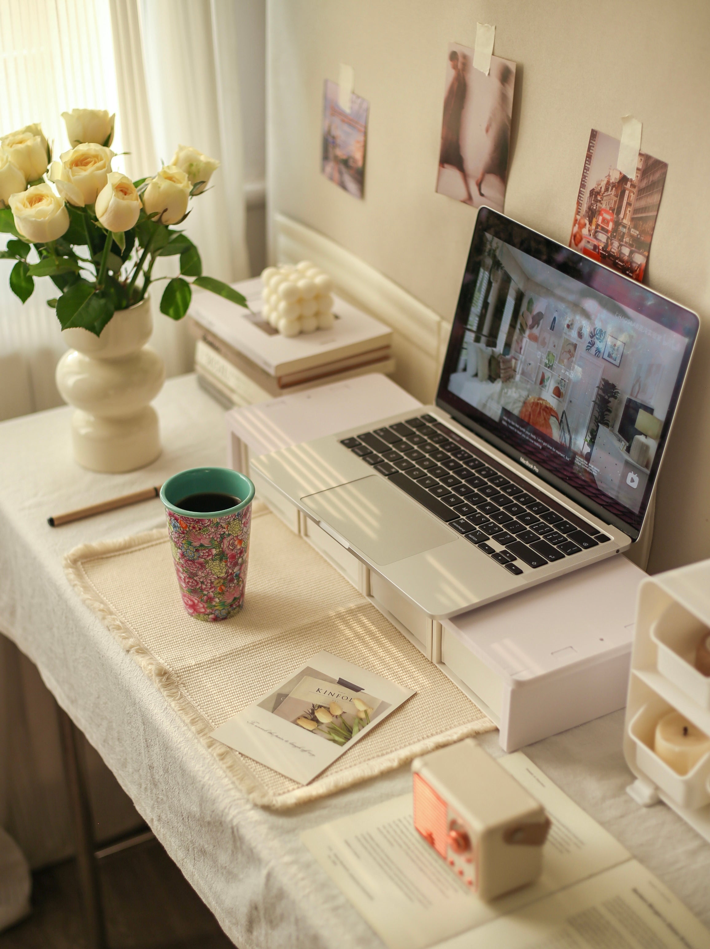 Laptop on a desk with flowers and a Falangcai mug in a home office setting