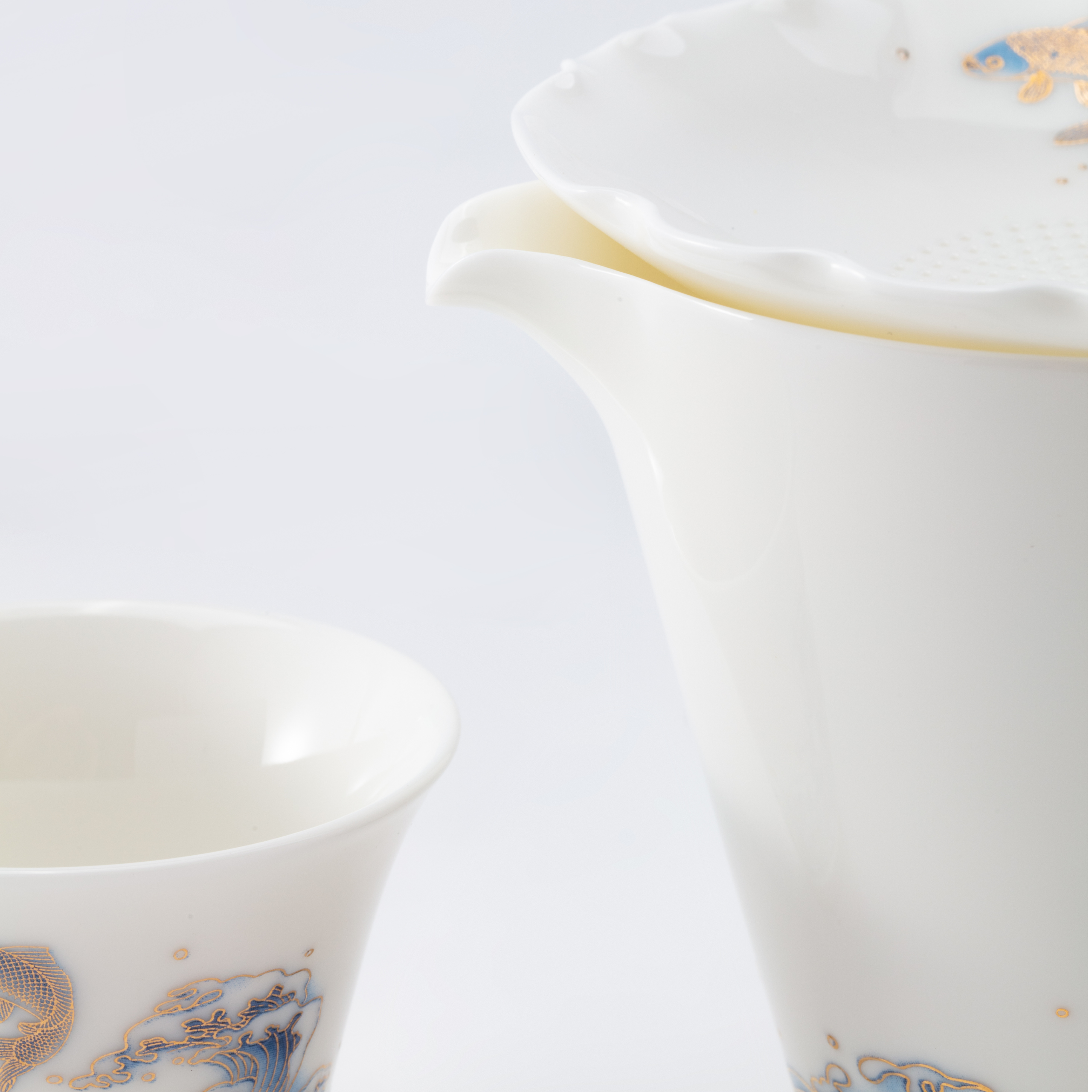 White ceramic tea fair cup and a cup with decorative elements on a light gray background