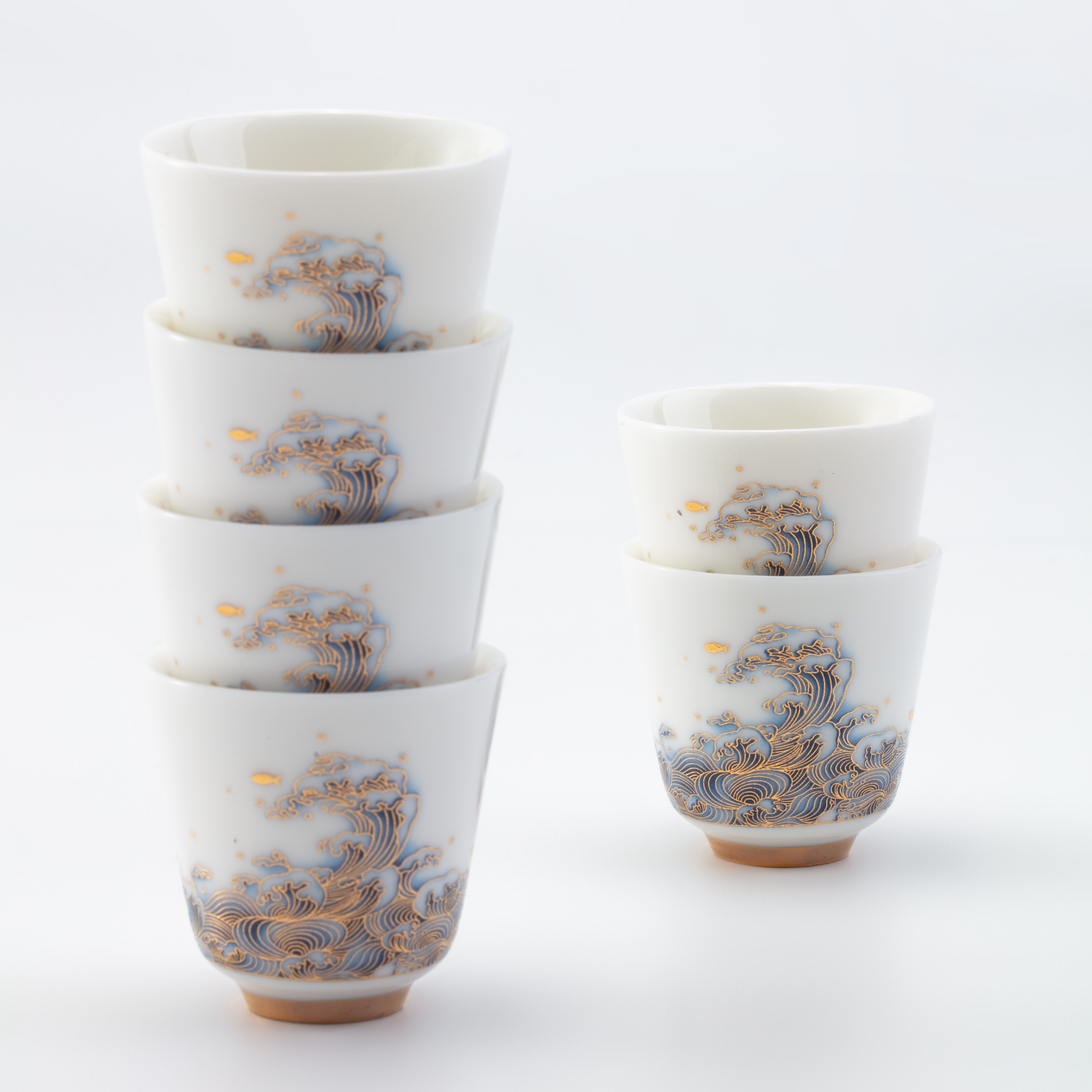 Set of white ceramic cups with decorative patterns on a white background