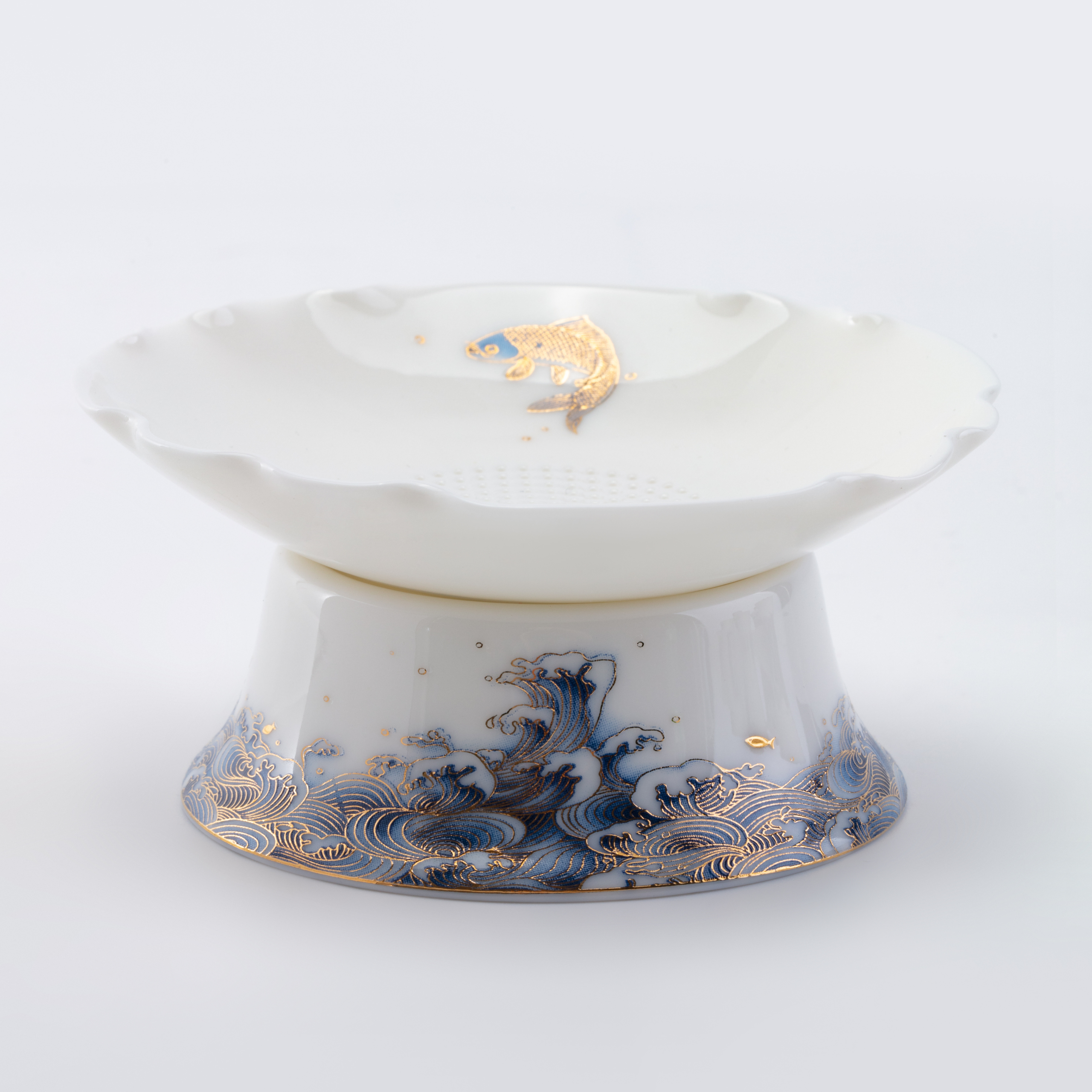 White ceramic teapot with blue wave design and gold accents on a white background