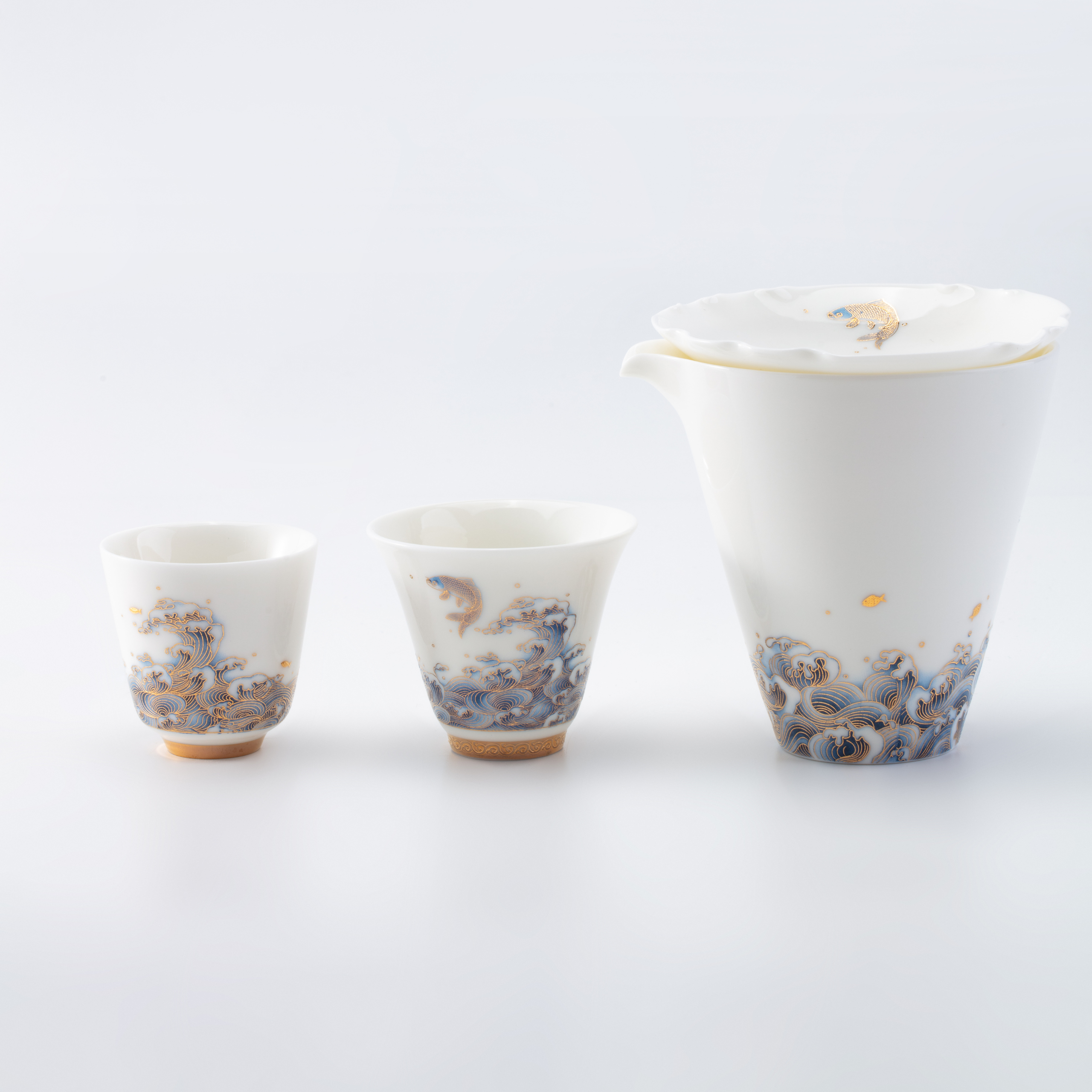 Ceramic teapot and two cups with floral patterns on a white background