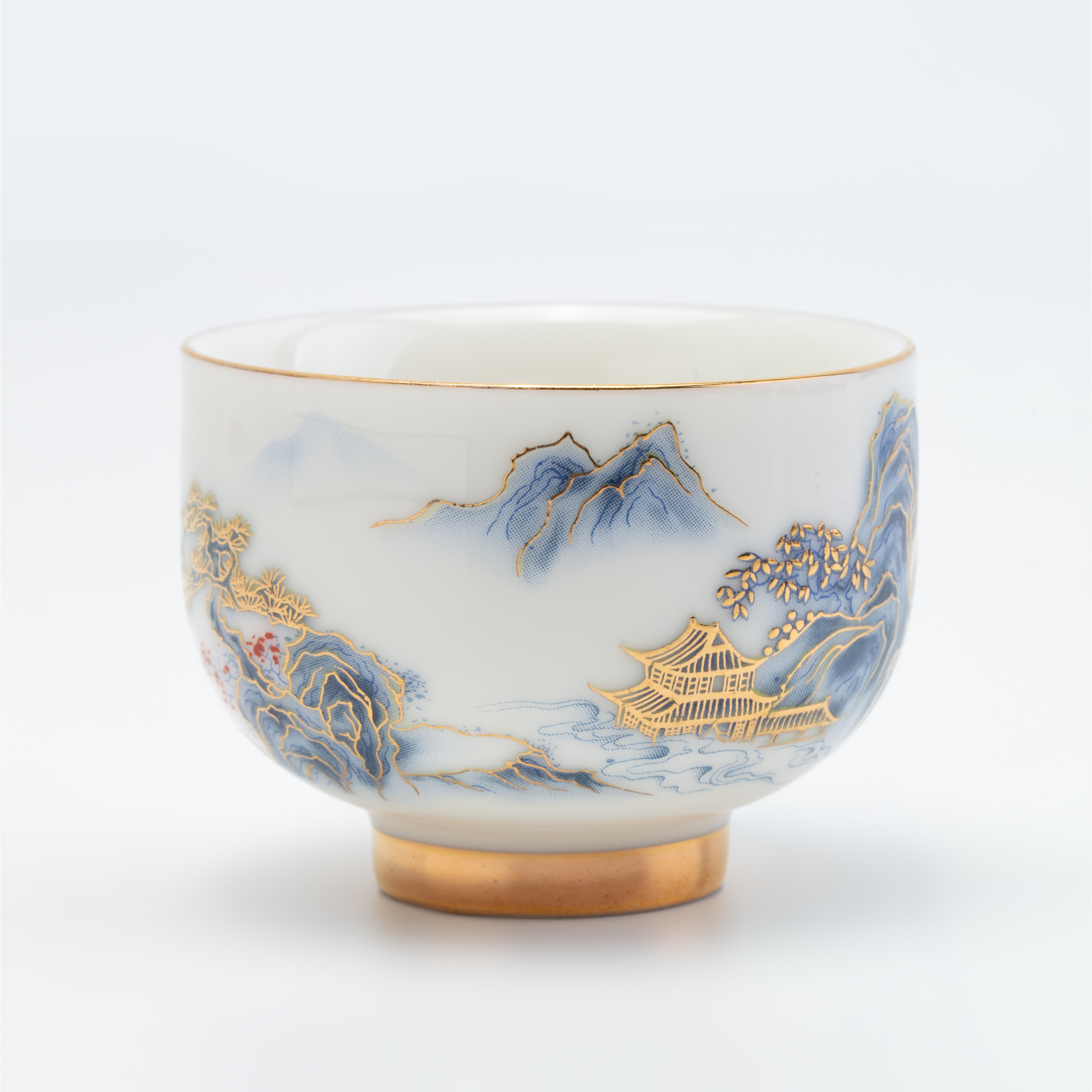 Decorative ceramic cup with artistic mountain and landscape design on a white background
