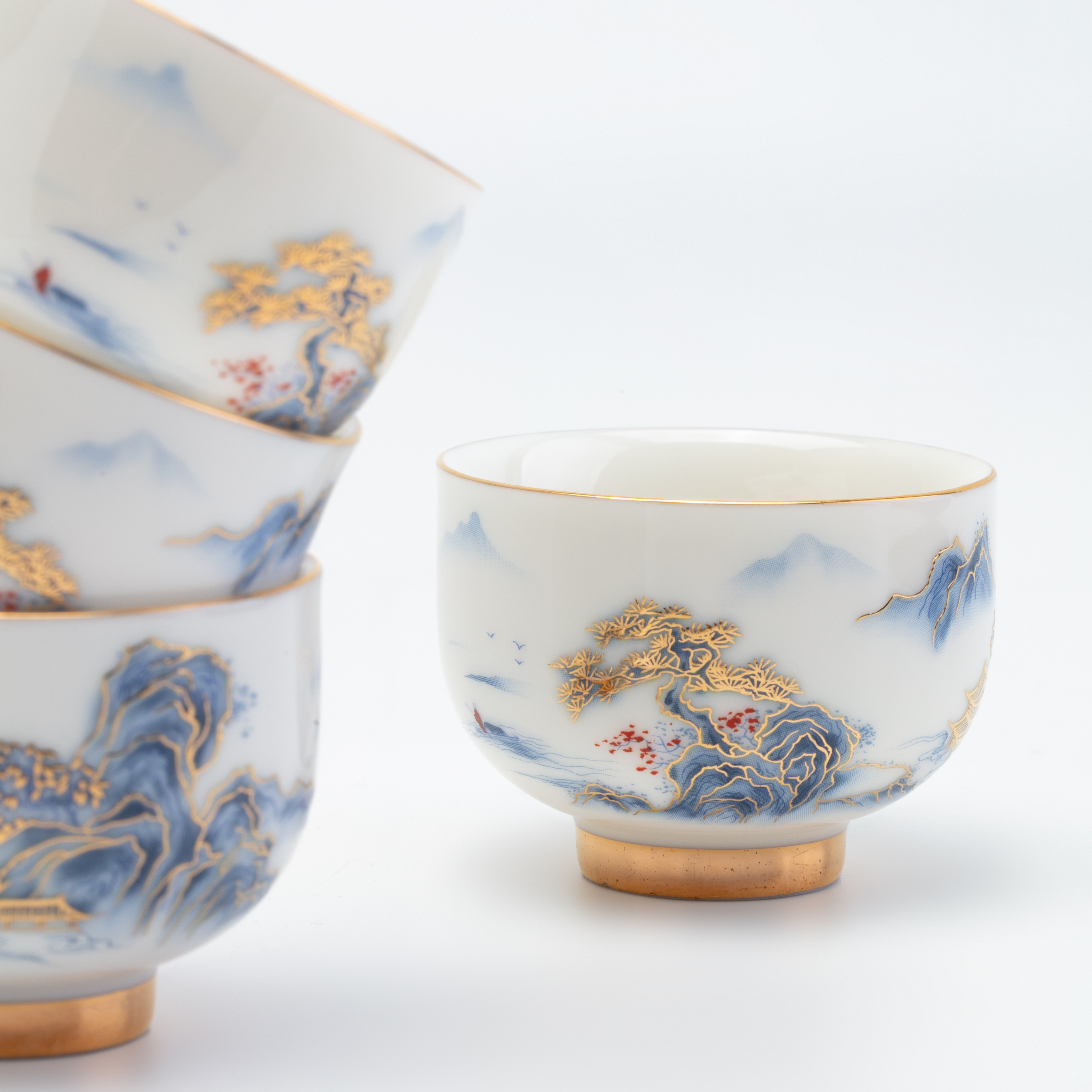 Set of ceramic cups with artistic designs on a white background