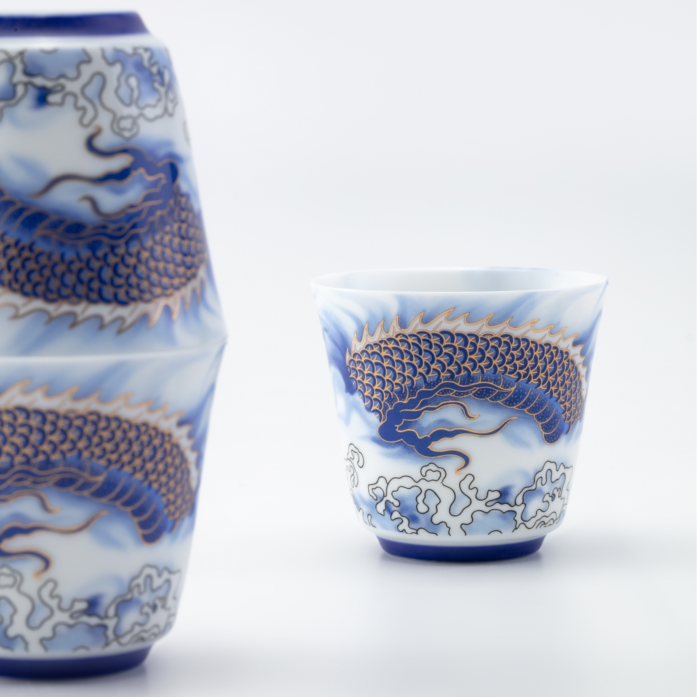 Two ceramic cups with blue dragon designs on a white background