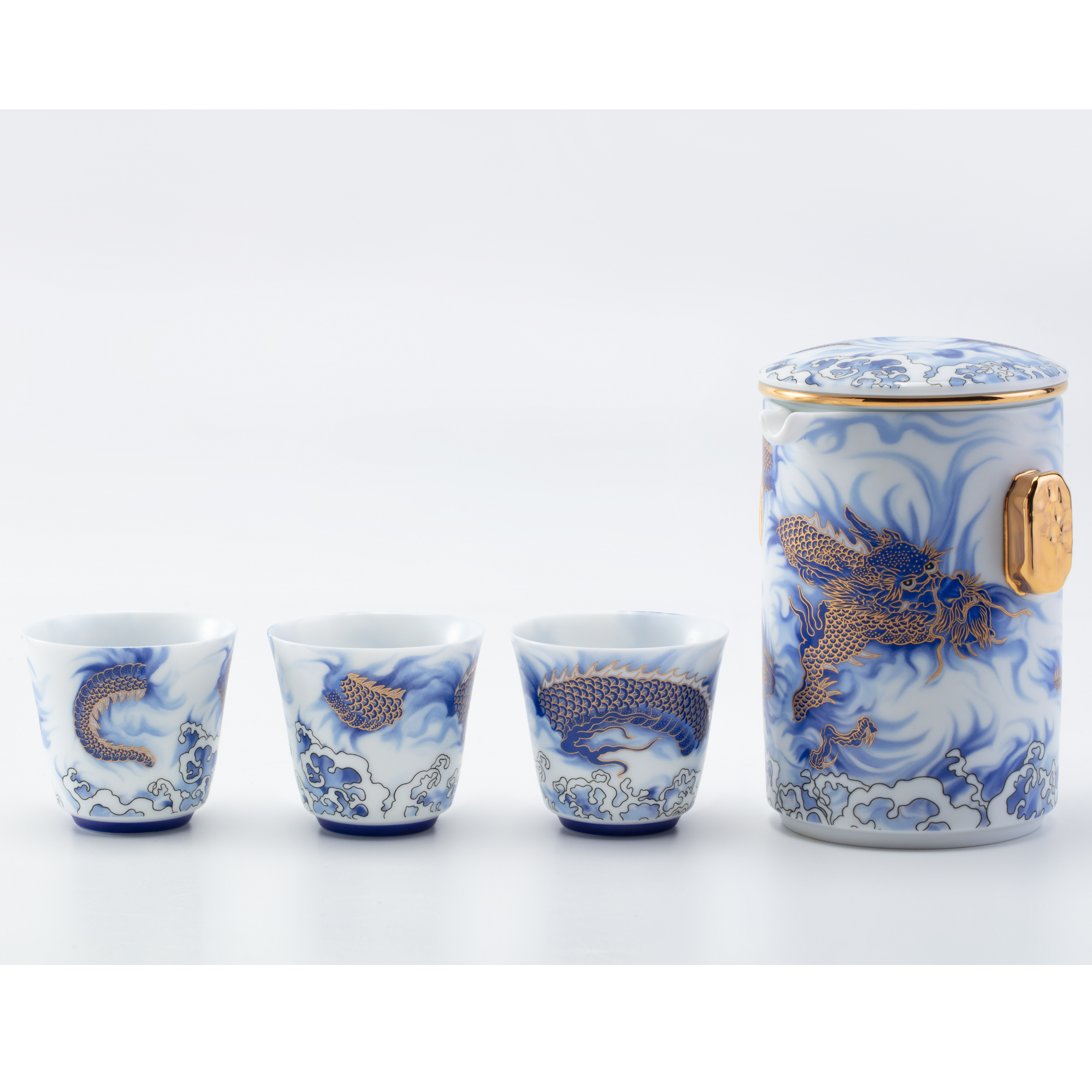 Set of blue and white ceramic tea set with gold accents on a white background