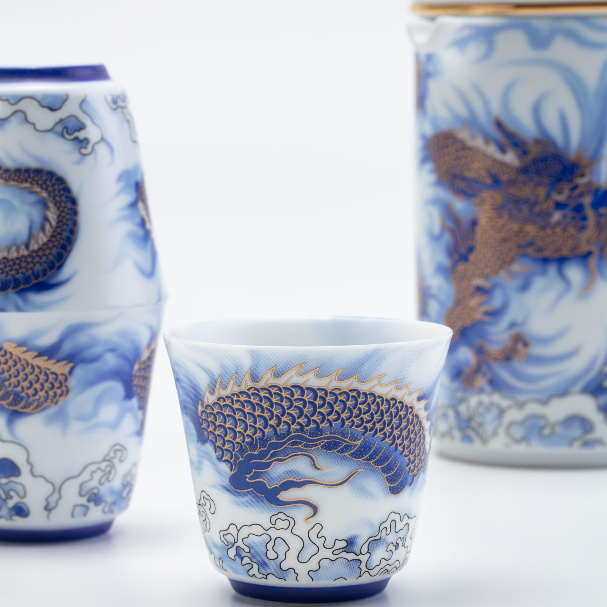 Ceramic cups with blue and white dragon design on a white background
