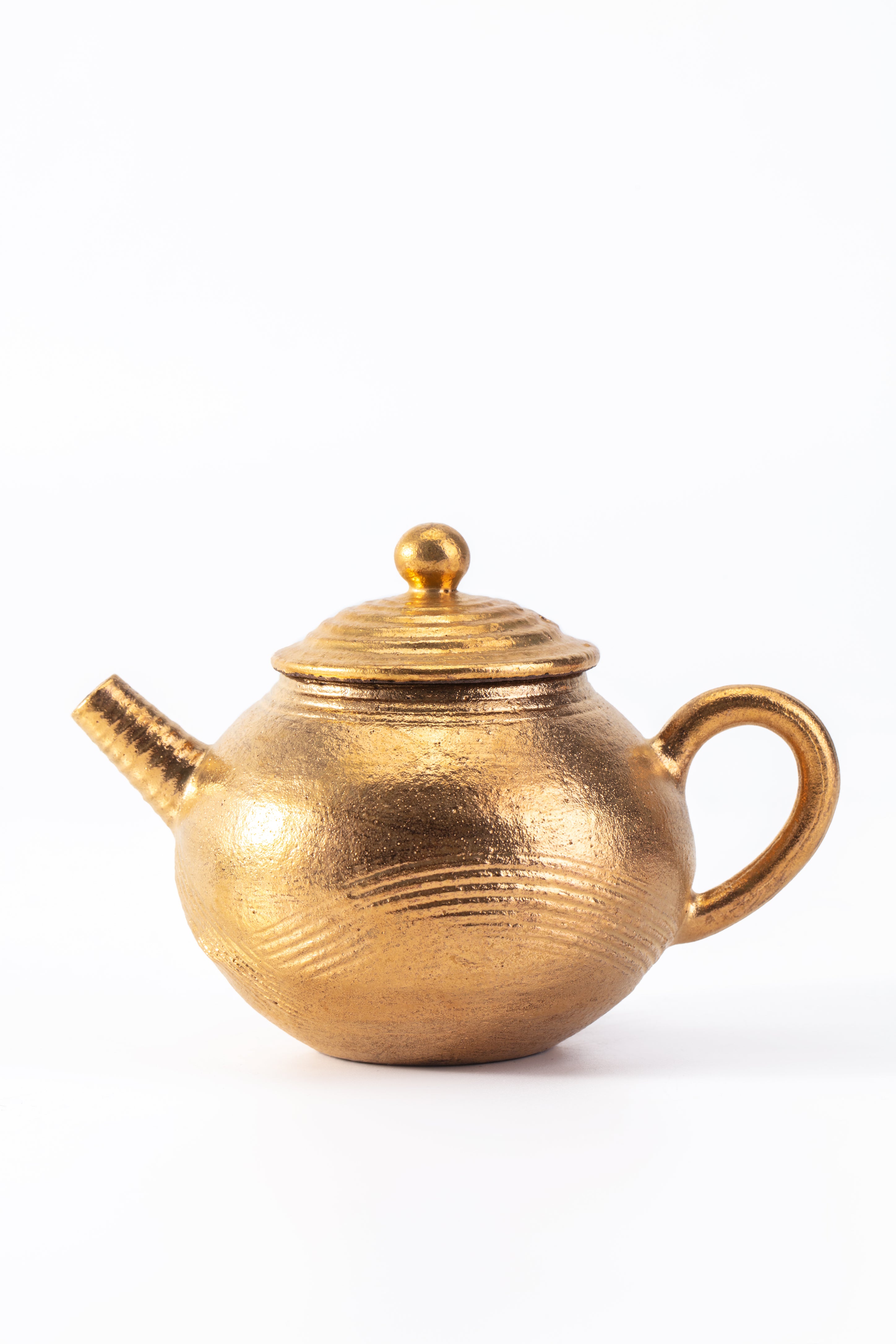 Gold teapot on a white background