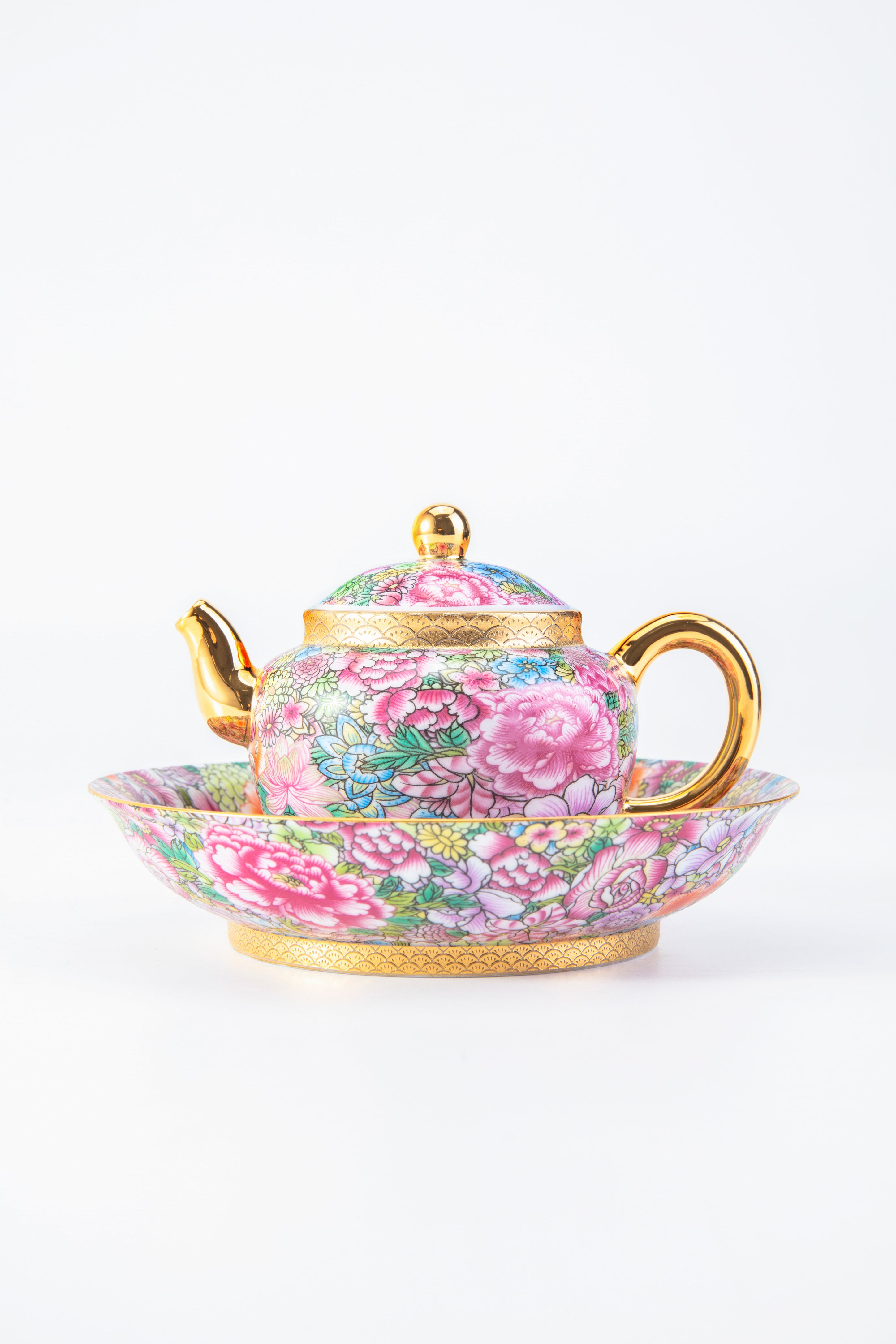 Floral teapot and saucer set on a white background