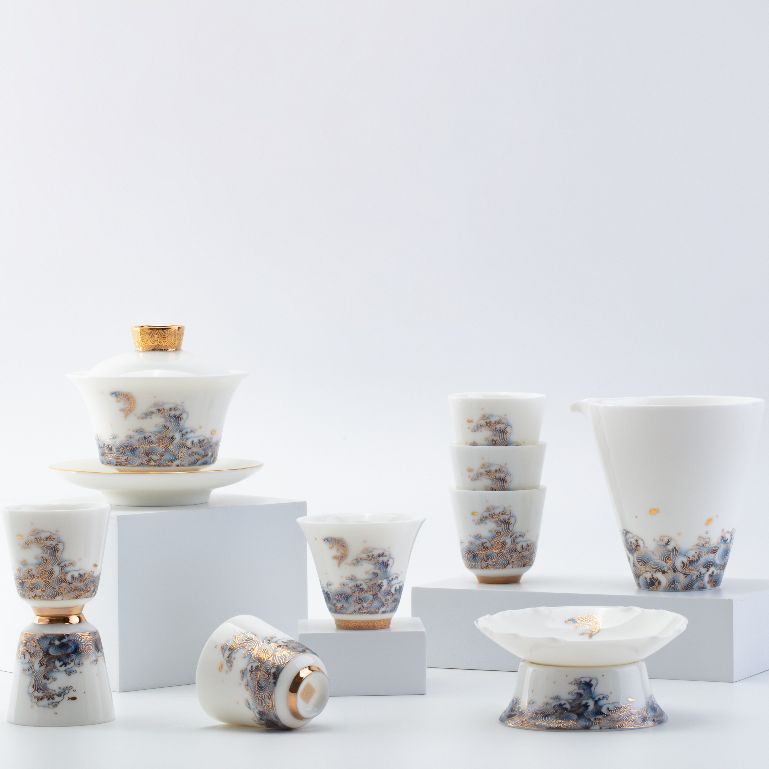 Set of ceramic tea cups and saucers with floral patterns on a light gray background