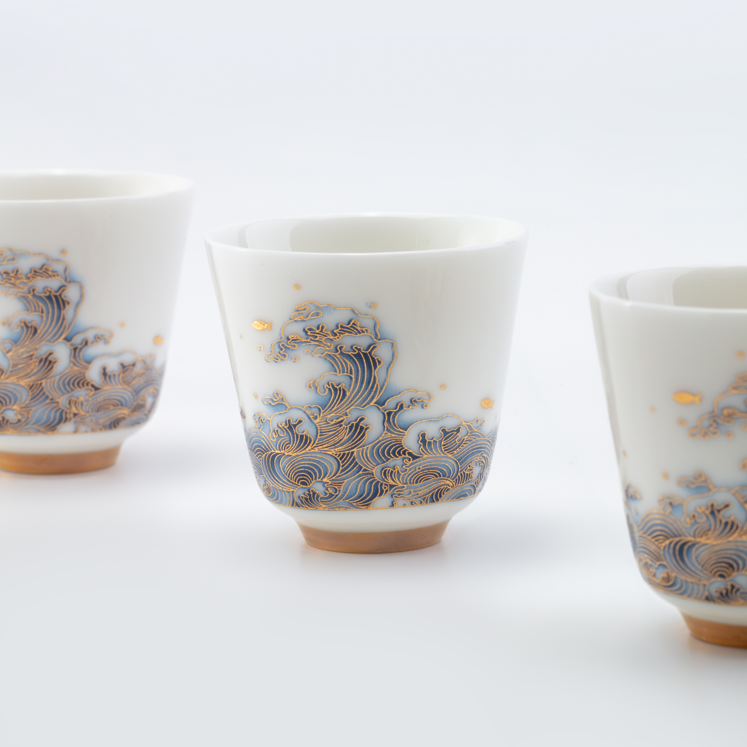 Three ceramic cups with wave patterns on a white background