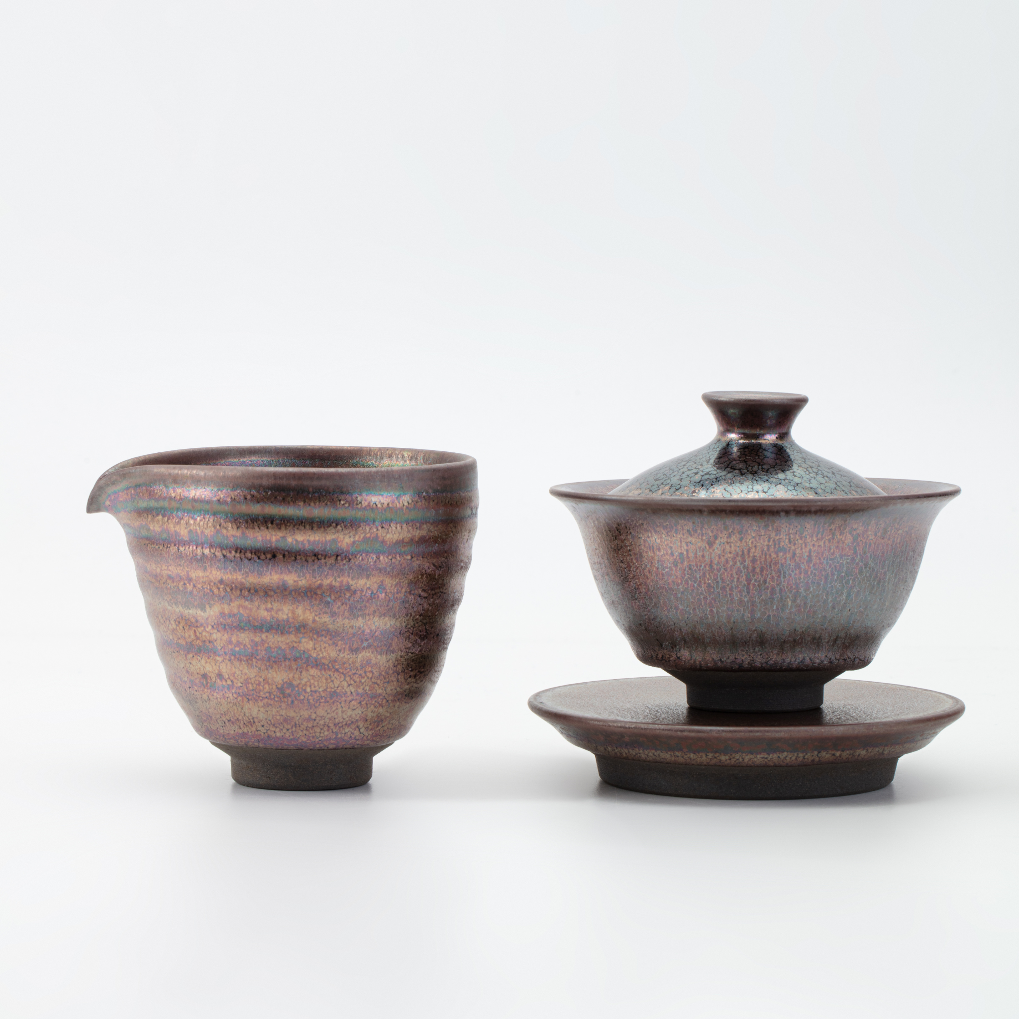 Ceramic teacup, teapot, and saucer set on a white background