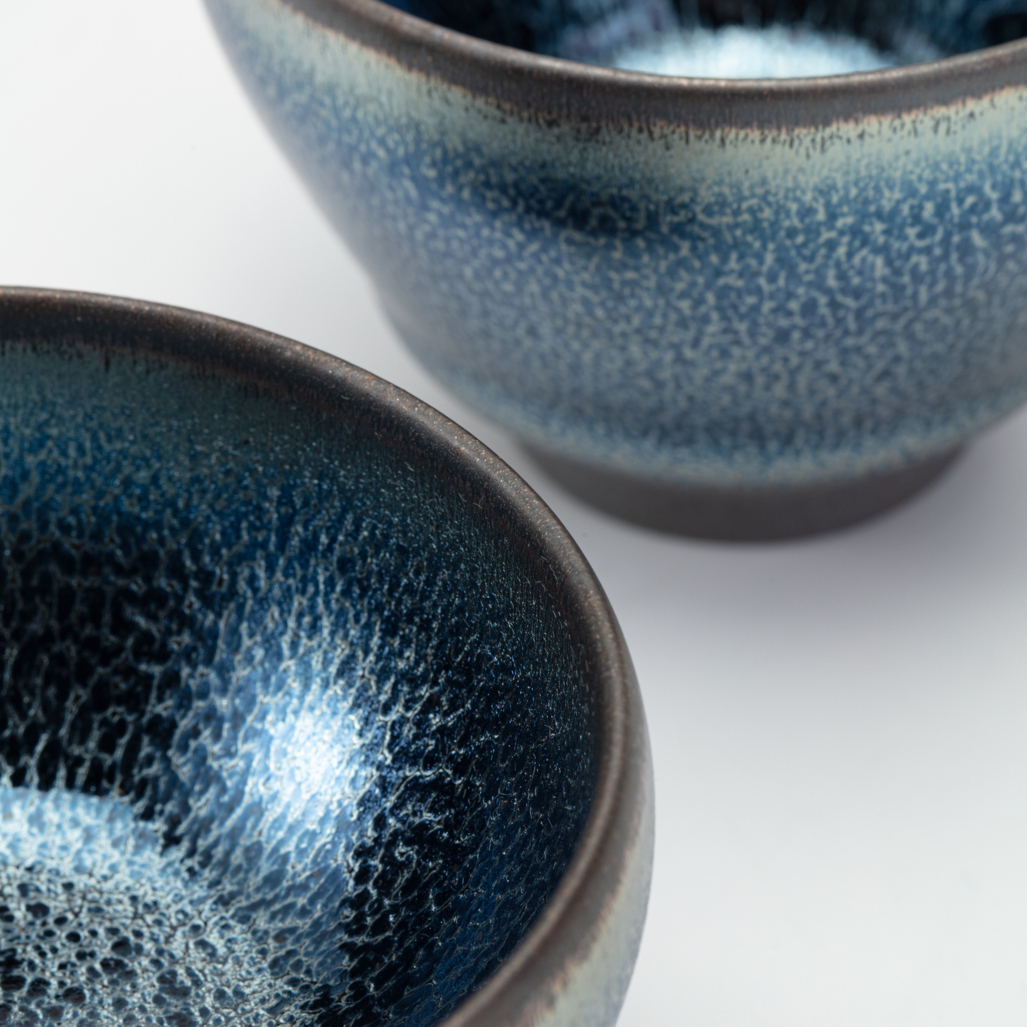Two blue ceramic bowls with a textured finish on a white background