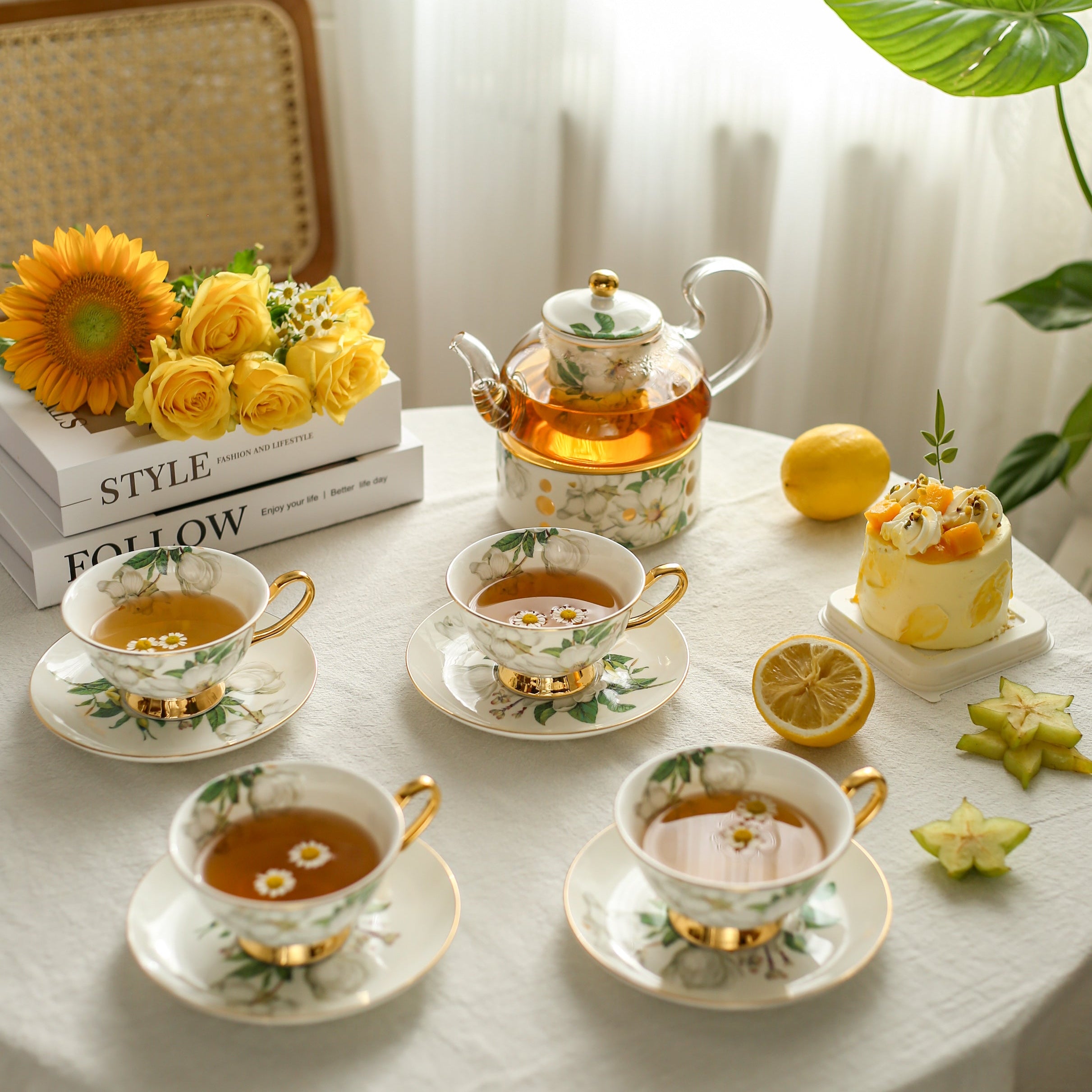 Tea set with cups, teapot, and lemon on a table with decorative elements.
