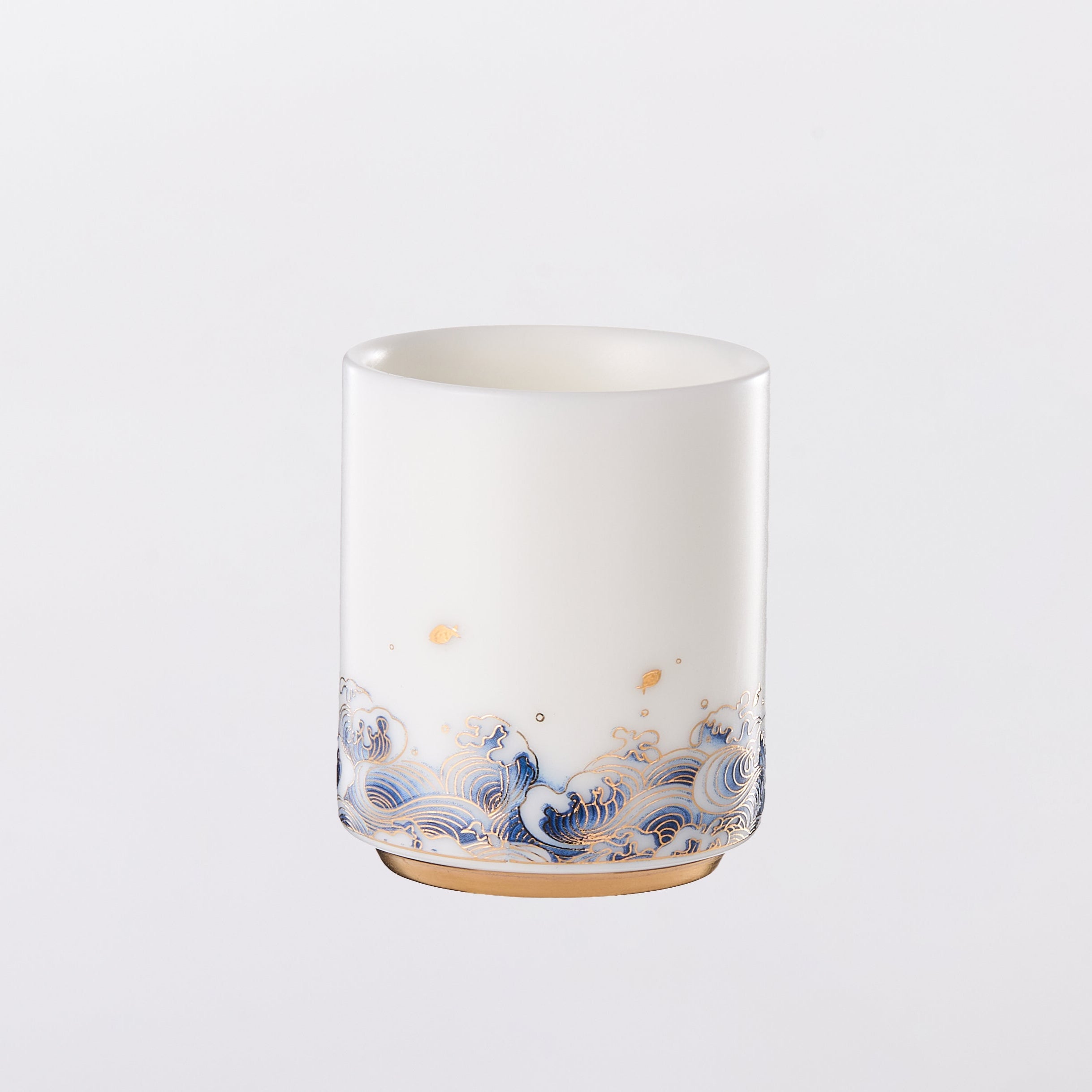 White ceramic tumbler with blue floral pattern on a light gray background