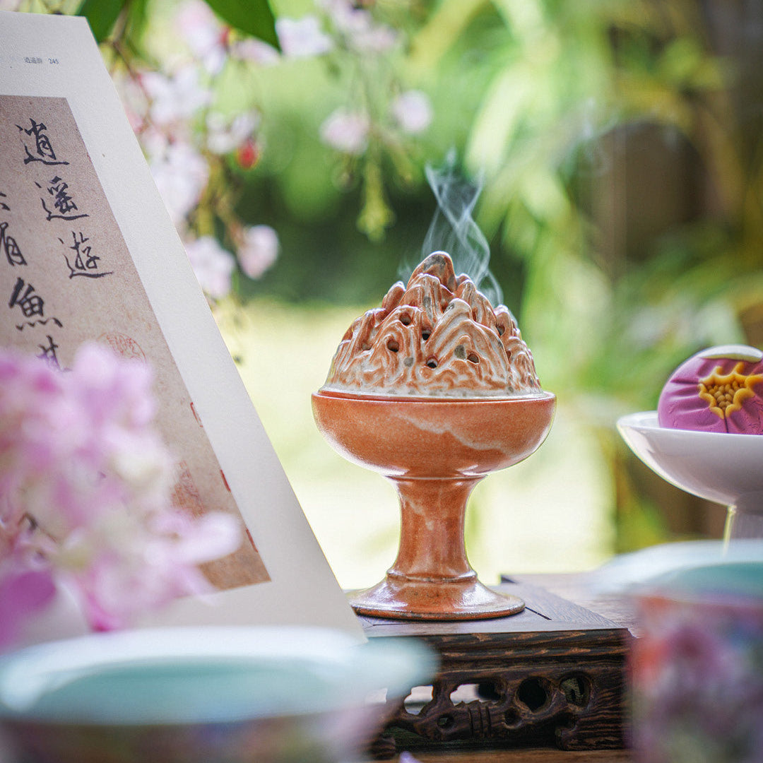 Ceramic incense burner with smoke in a garden setting